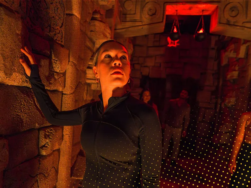 A player against the torch-lit stone wall of the Mayan Tomb room
